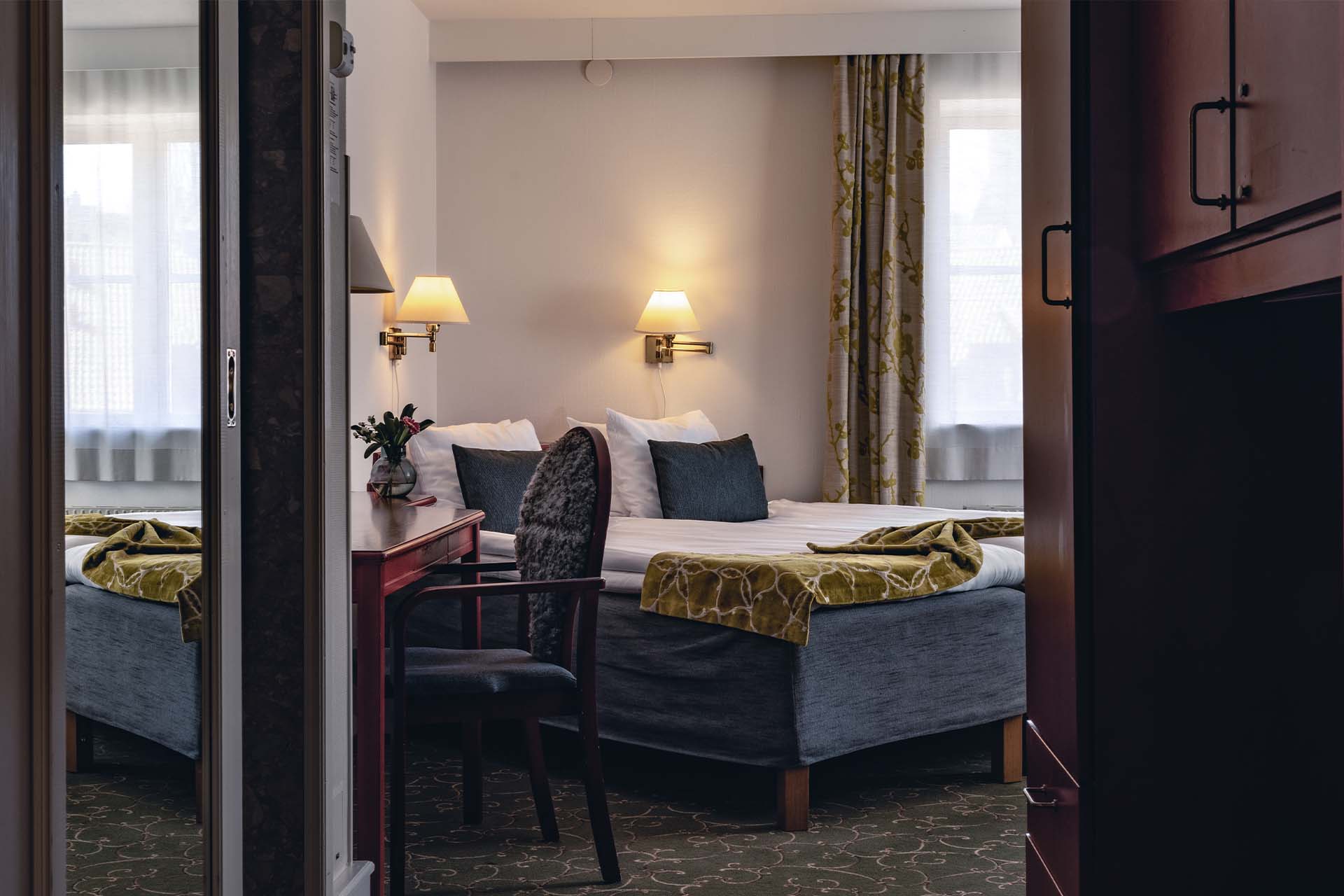 Rum med garderob och dubbelsäng på Strand Hotel
